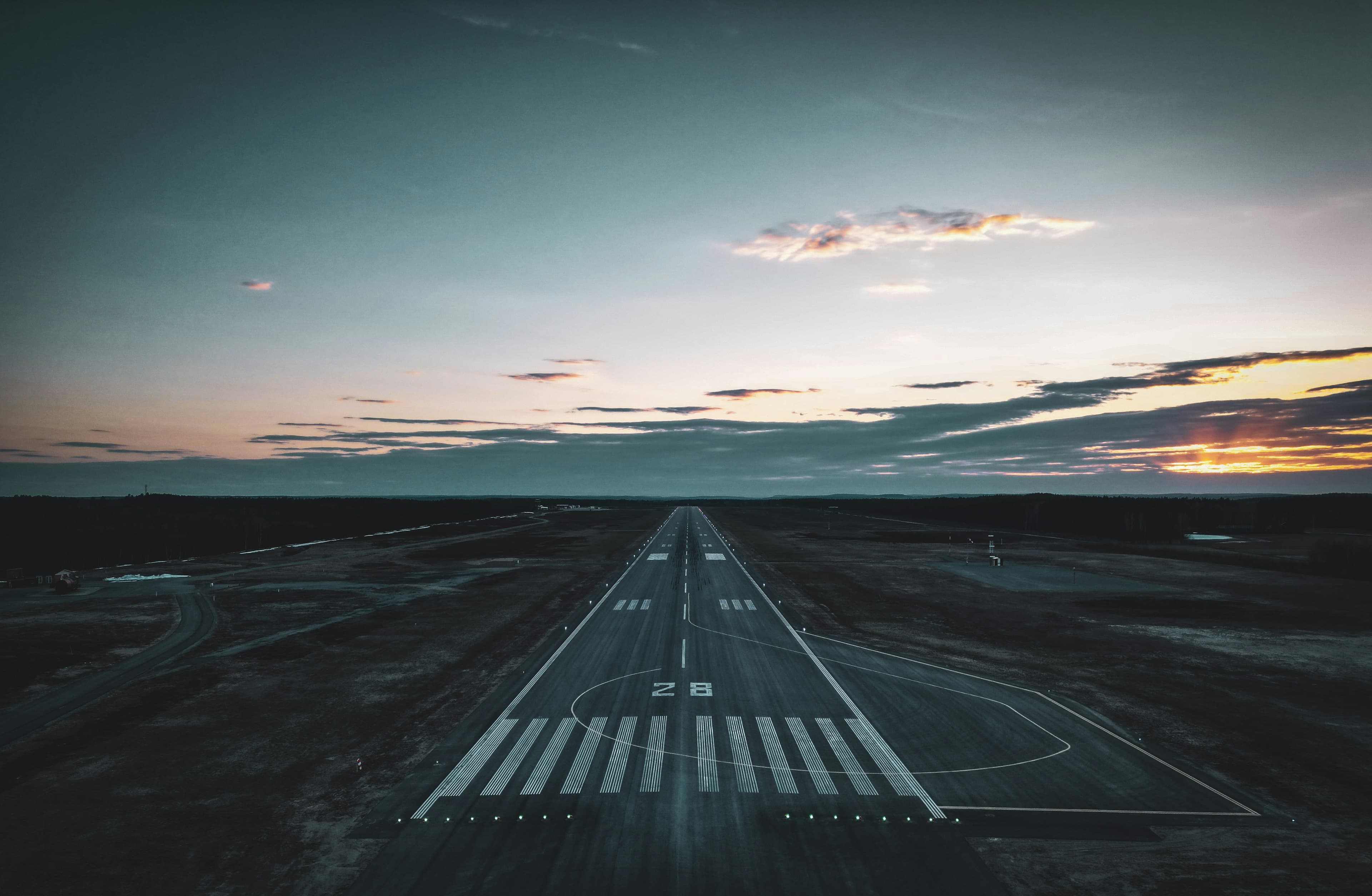 Empty runway at dusk under a dramatic sky